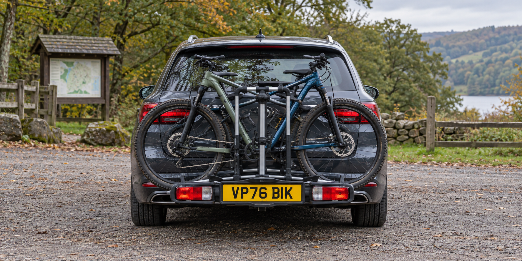 Dark grey estate car with two bicycles on a rear carrier and a complete yellow VP76 BIK plate visible on the carrier lighting board