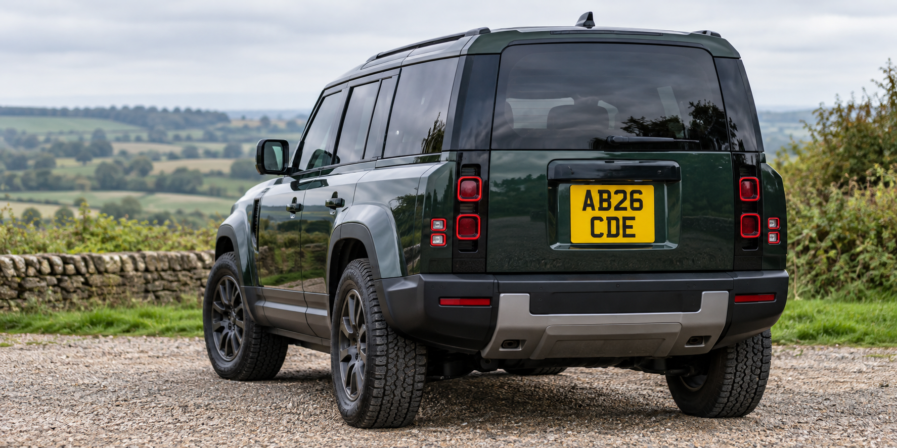 Rear of a dark green 4x4 with a complete yellow square plate displaying AB26 over CDE
